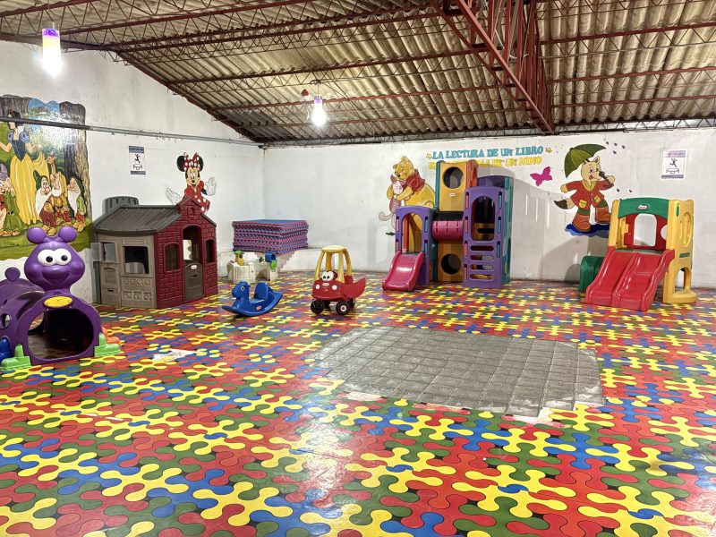 Zona de juegos techada con toboganes y casita